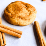 close up of apple pie snickerdoodle with cinnamon sticks on parchment paper