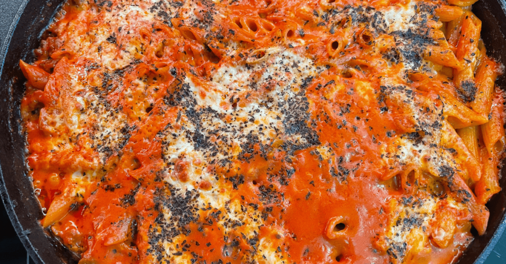 baked penne pasta in a cast iron skillet