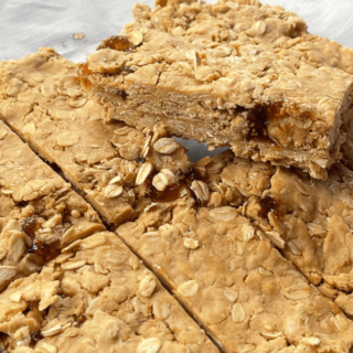 no bake peanut butter and jelly bars cut into 8 bars with one resting on top of the other bars showing the layer of jam