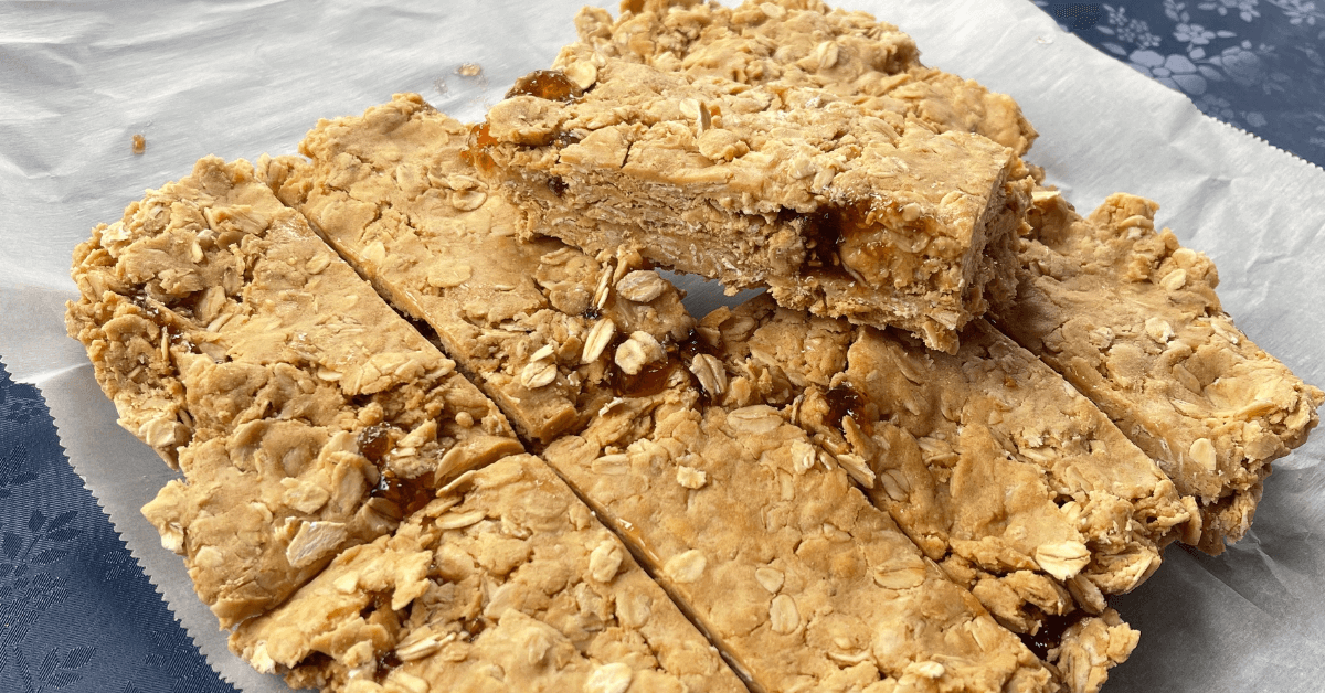 no bake peanut butter and jelly bars cut into 8 bars with one resting on top of the other bars showing the layer of jam