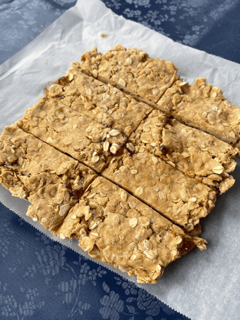 peanut butter and jelly oat bars cut into 8 pieces on parchment paper