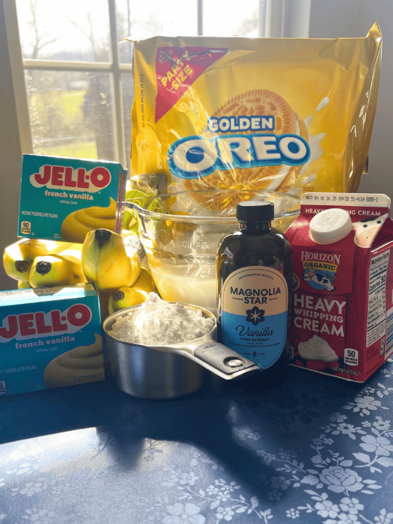 shot of recipe ingredients: golden oreos, heavy cream, vanilla, powdered sugar, french vanilla pudding, milk, and bananas
