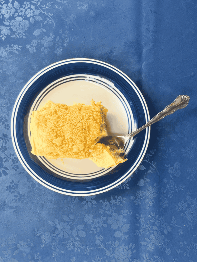 overhead shot of golden oreo banana pudding on a plate with a spoon carving out a bite