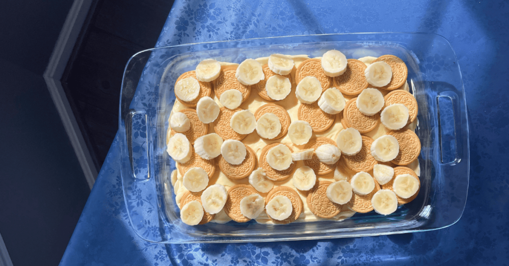 the middle layer of the Golden Oreo Banana pudding showing the second layer of oreos and banana slices on top of the first pudding layer