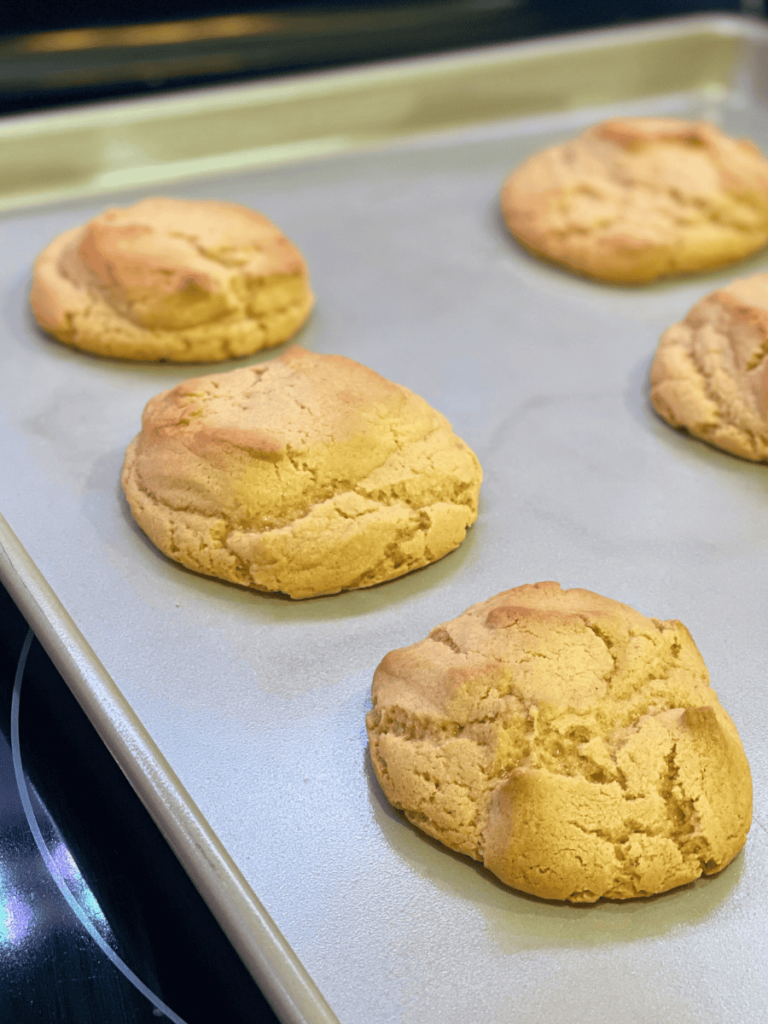 baked peanut butter cookies cooling on a baking tray
