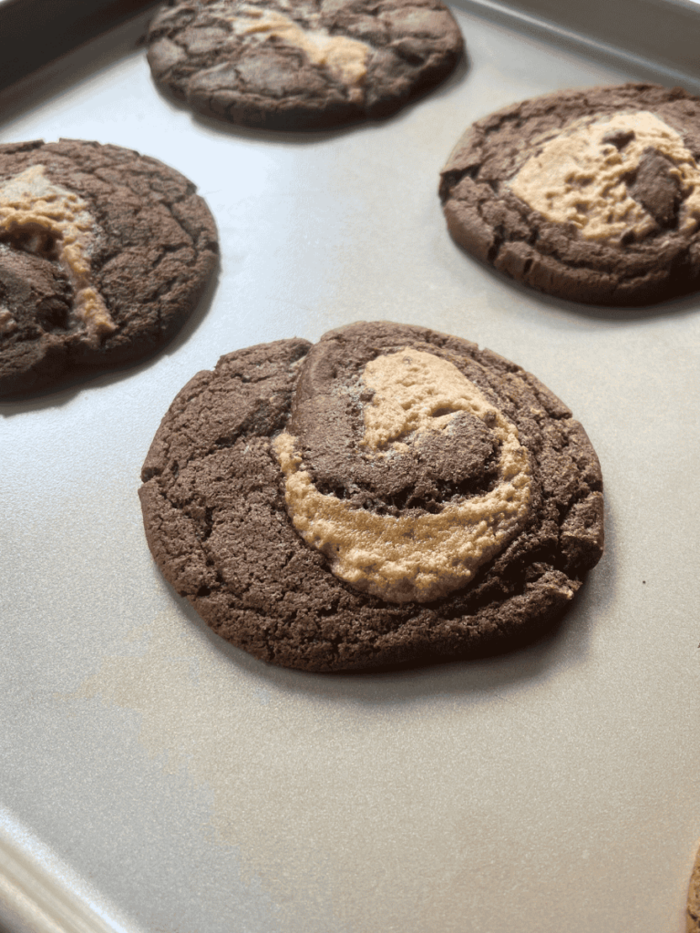 peanut butter brownie swirl cookies cooling on a baking sheet