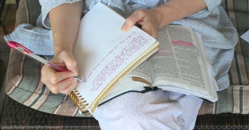 woman journaling with opened bible on her lap