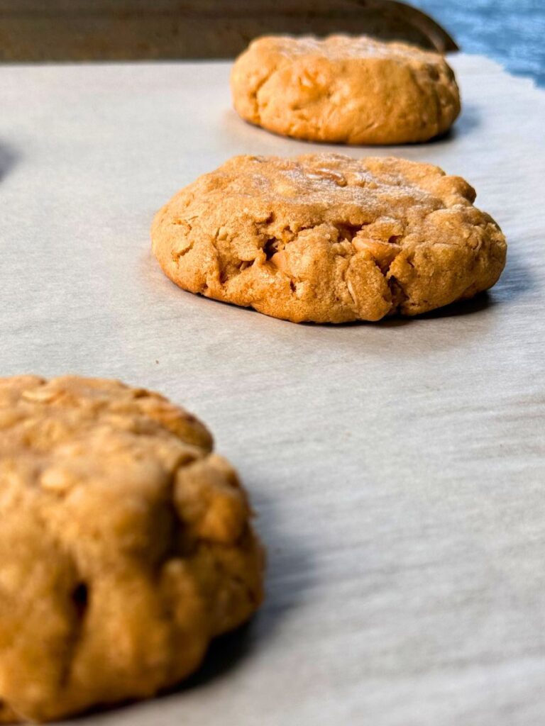 peanut butter oatmeal cookies with butterscotch chips cooling on parchment paper