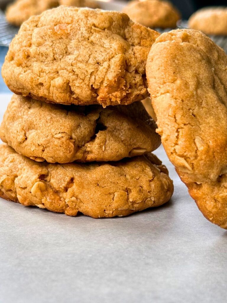 a stack of peanut butter oatmeal cookies with butterscotch chips resting on parchment paper